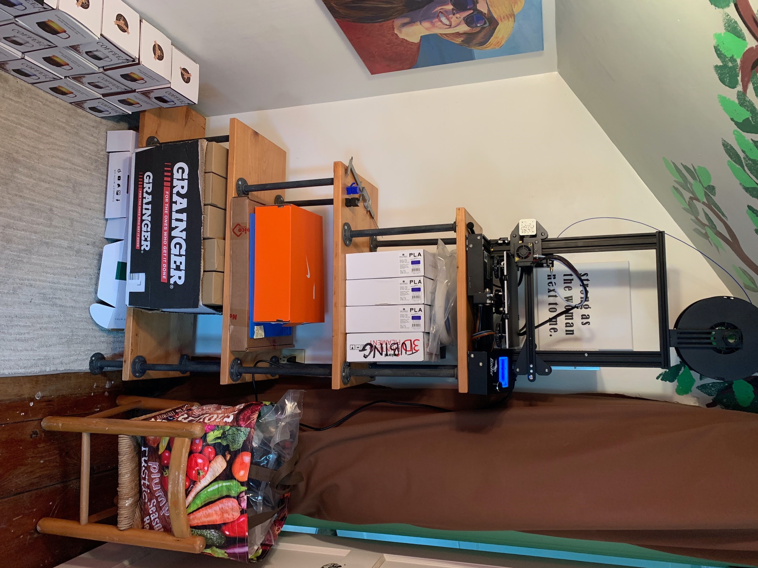 One of our many 3D printers, sitting over boxes of
        device components in Olivia’s childhood bedroom.